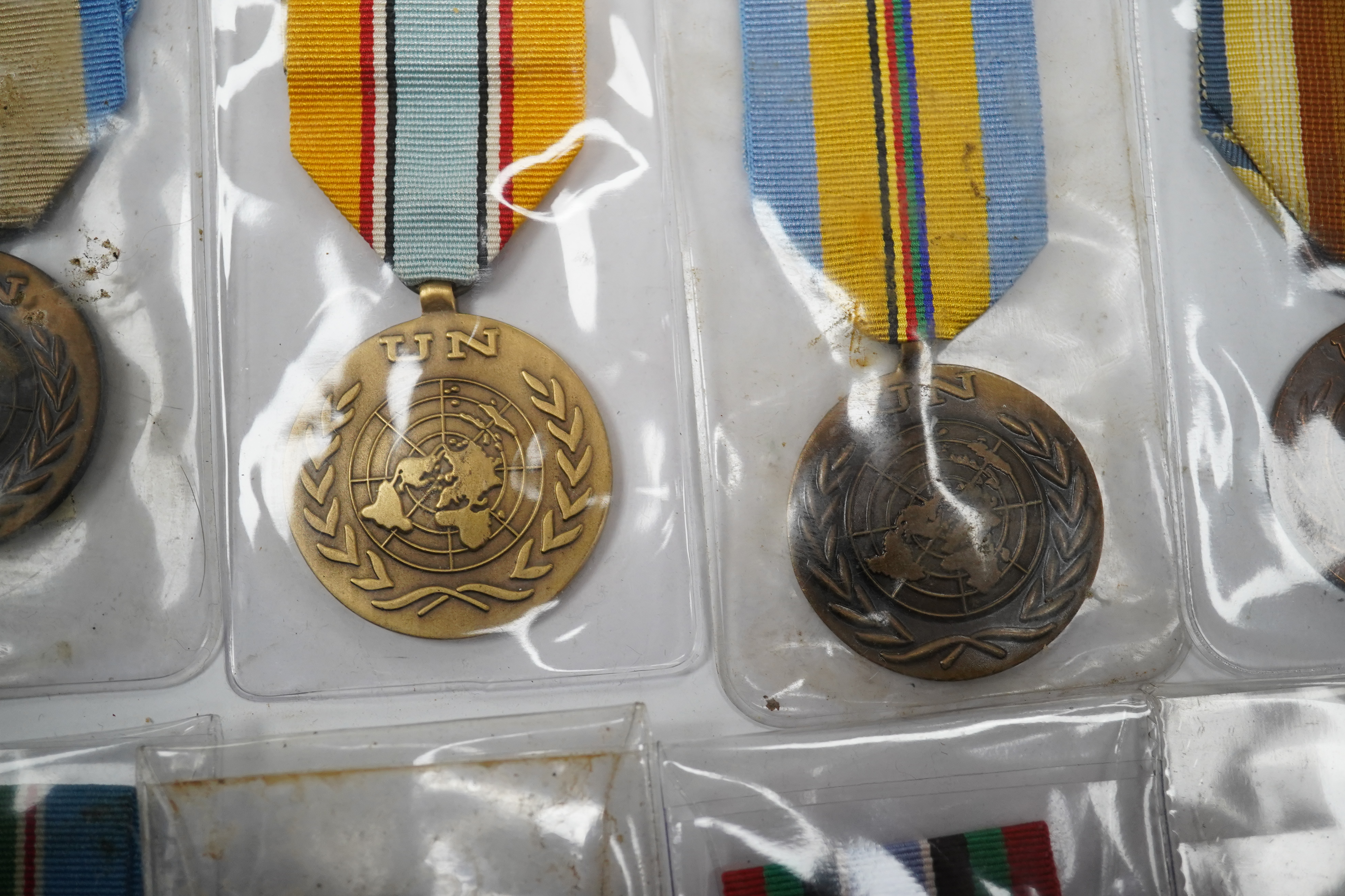 Thirteen United Nations (UN) and NATO medals, eleven UN examples with ‘ in the service of peace’ to the reverse, including a variety of ribbons for a number of different campaigns, (some duplicates), and two NATO ISAF Af